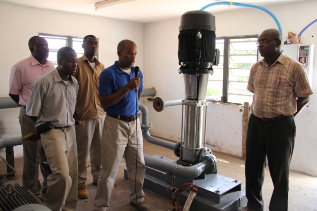 Manager of the Nevis Water Department, Roger Hanley (with the mike) with Electrical Technicians Clyshawn Wilson (front left) and Gavin Walters (back right), Assistant Secretary in the Ministry of Communication and Works and Public Utilities Denzil Stanley (back left) and Permanent Secretary in the Ministry of Communication and Works and Public Utilities Ernie Stapleton with the newly installed booster pump at the Fothergills Water Pumping Station on March 07, 2014